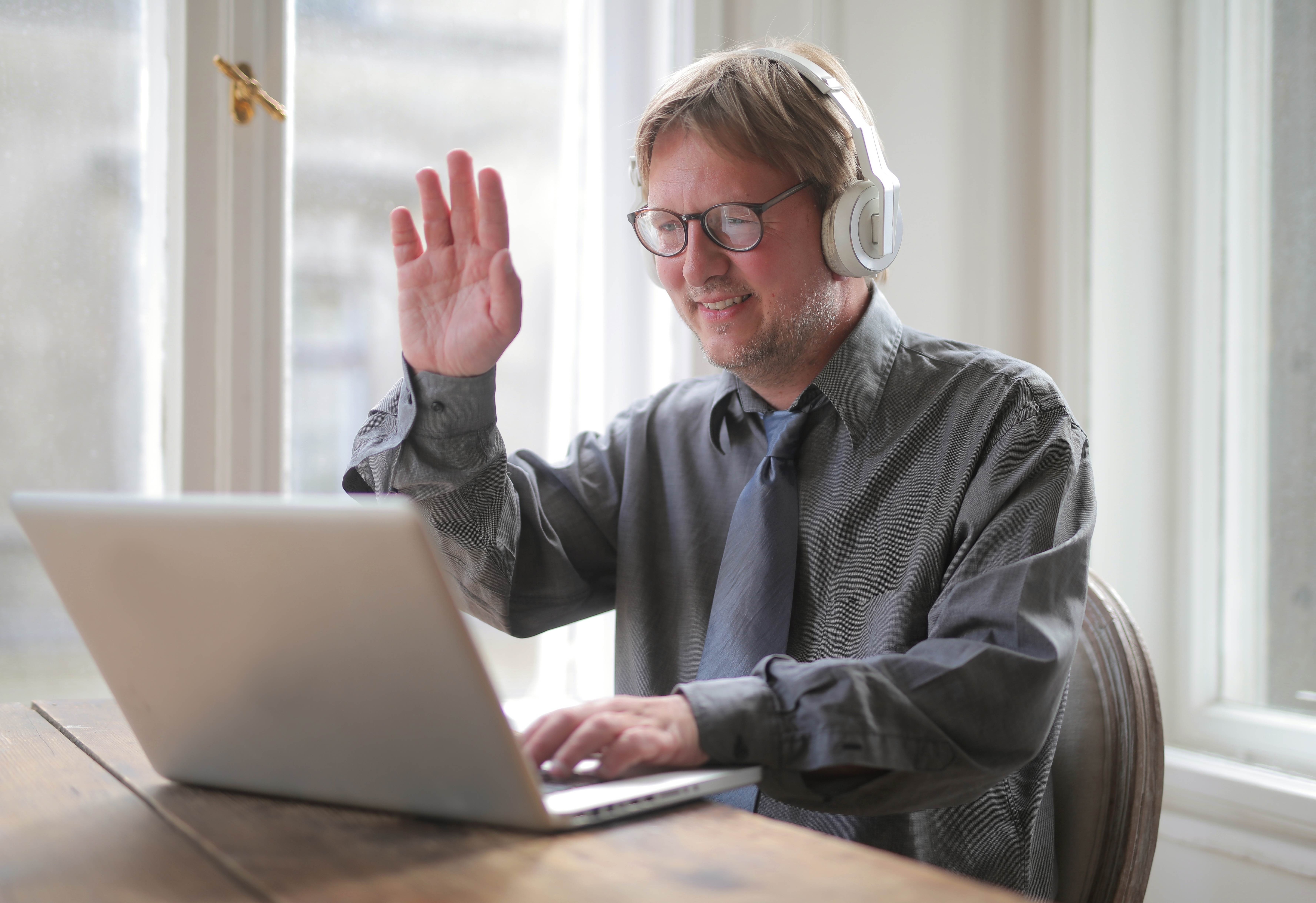 A man smiling and greeting an online guest.